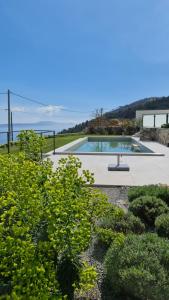 vista para uma piscina num jardim em Kvarner Luxus Suite am Meer em Lovran