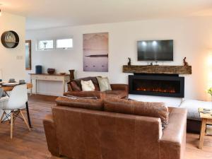 uma sala de estar com um sofá e uma lareira em The Wood House em Buckfastleigh