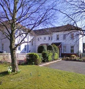 a large white house with a tree in the yard at Idyllic views over Loch Leven. Excellent location in Gateside