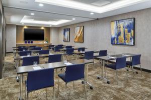 a conference room with tables and chairs and a tv at Courtyard New York Manhattan/Midtown West in New York