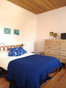 Schlafzimmer mit einem Bett mit blauer Bettwäsche und einer Kommode in der Unterkunft Idyllic views over Loch Leven. Excellent location in Gateside