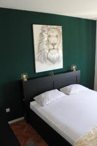 ein Bett mit einem Bild eines Löwen an einer grünen Wand in der Unterkunft Cozy Corners in Nin