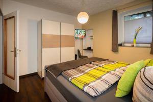 トラーベン・トラーバッハにあるFerienwohnung Ginsterbergのベッドルーム1室(黄色い毛布付きのベッド1台付)