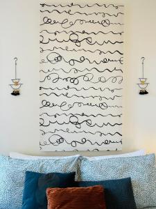 a bedroom with a bed with a painting of waves at Rooms & Apartments La Casa di Loreto in Rovinj