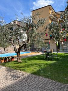 un parco con tavolo e albero di fronte a un edificio di Appartamenti Villa Dall'Agnola a Garda
