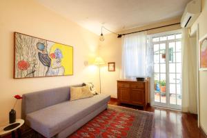 a living room with a couch and a painting on the wall at Vila Chácara Flora em Malveira da Serra in Alcabideche