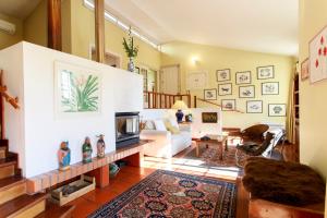 a living room with a white couch and a tv at Vila Chácara Flora em Malveira da Serra in Alcabideche