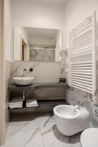 Alle Guglie Boutique Hotel في البندقية: حمام أبيض مع حوض ومرحاض