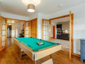 a pool table in a living room with a kitchen at The Big Hoose in Achnahanat