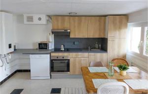 1 Bedroom Beautiful Apartment In Cucq في كوسيك: مطبخ مع دواليب خشبية وطاولة خشبية مع الوضوء