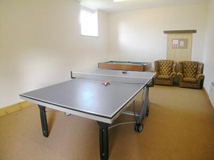 a ping pong table in a room with two chairs at Chapman House in Parkham