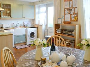 a kitchen with a table and a kitchen with a washing machine at Tregatta Terrace in Tintagel