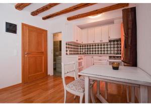 Una cocina con una mesa y sillas en una habitación. en San Cristoforo Accommodations Rovinj - Garzotto, en Rovinj