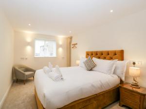 1 dormitorio con 1 cama blanca grande y 1 silla en Bilsham Meadows en Bristol