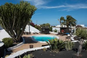 a swimming pool in a resort with trees and plants at Casa Berriel 2 in Tías