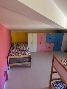 een slaapkamer op zolder met een bed en kleurrijke kasten bij Villa Green garden in Carlentini