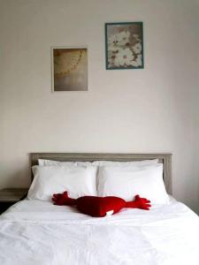 un oso de peluche rojo sobre una cama blanca en KA701-One Bedroom Apartment- Wifi -Netflix -Parking - Pool, 1002, en Cyberjaya
