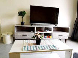 a living room with a tv and a coffee table at KA701-One Bedroom Apartment- Wifi -Netflix -Parking - Pool, 1002 in Cyberjaya