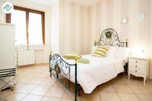a bedroom with a bed with white sheets and green pillows at La Casina Del 5 by TuscanyWeGo in Villa Bertolli