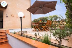 a patio with a table and an umbrella at La Casina Del 5 by TuscanyWeGo in Villa Bertolli +22 photos
