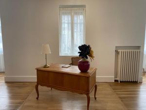 una habitación con una mesa con un jarrón encima en Appt 130m2-Jusqu'à 3 Chambres-Centre ville-Moulins-Le Pal en Moulins