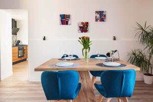 een eetkamer met een houten tafel en blauwe stoelen bij Gîte de L'Abri-Côtier 14 in Pontorson