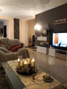 un soggiorno con candele sul tavolo di fronte a una TV di Bungalow am Meer a Grzybowo