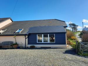 ein blau-weißes Haus mit einem Fenster in der Unterkunft Cwmwdig Cwtch (3 minutes drive to Abereiddy bay!) in Haverfordwest