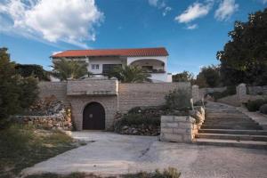 ein Backsteinhaus mit einem Tor und einer Einfahrt in der Unterkunft Villa Nikolina in Molat