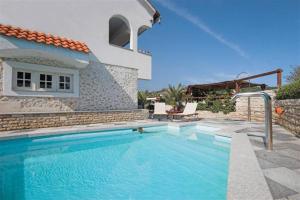 ein Swimmingpool vor einer Villa in der Unterkunft Villa Nikolina in Molat