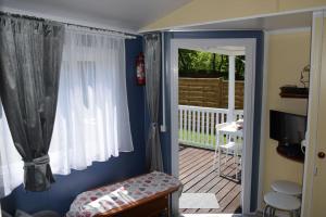 a room with a door open to a porch with a deck at Wakacyjny Domek Słoszów 3 in Duszniki Zdrój