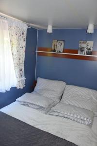 1 dormitorio con 1 cama con pared azul en Wakacyjny Domek Słoszów 3 en Duszniki Zdrój