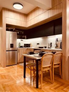 雅典的住宿－2 BedRoom Apt - Live Like a Local in Kolonaki，厨房配有桌椅和冰箱。