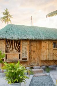 una casa de bambú con techo de hierba en GoOd Inn White Beach Moalboal en Cebú