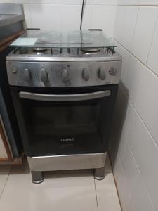 a black stove in a kitchen with a tile wall at Barra Summer Flat Apart in Salvador
