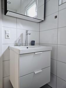 a white bathroom with a sink and a mirror at Weinstadt Monteurwohnnung Ferienwohnung in Weinstadt