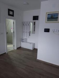 a room with white walls and a wooden floor at Apartman Jass in Stari Banovci