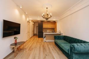 - un salon avec un canapé vert et une table dans l'établissement Main Street Sky House Apartments, à Chişinău