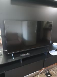 a flat screen tv sitting on a black shelf at Barra Summer Flat Apart in Salvador