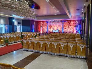 a large hall with rows of chairs and a stage at Hotel Midland, Nanded in Nānded
