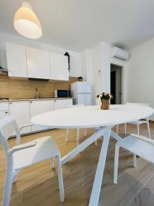a white dining room table and chairs in a kitchen at Casa di Tinny in Barbusi
