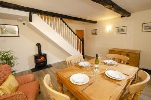 uma sala de jantar com uma mesa e um fogão a lenha em Skelwith Fold Cottage No.1 em Elterwater