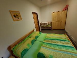 a bedroom with a bed with a green comforter at Ubytování u MVE in Ludvíkov