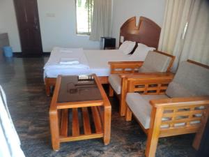 a room with two beds and a couch and a table at SAIKUSHI BEACH RESORT in Kundapur