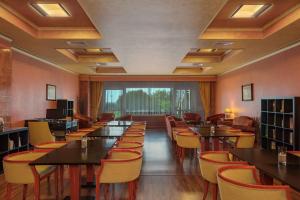 a restaurant with tables and chairs and a large window at Rome Marriott Park Hotel in Rome