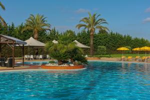 a large swimming pool with palm trees and umbrellas at Rome Marriott Park Hotel in Rome
