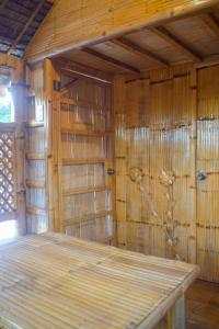 Habitación vacía con paredes de madera y mesa de madera. en GoOd Inn White Beach Moalboal en Cebú