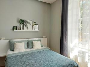 Un dormitorio con una cama con una manta azul y una ventana. en Zagreb Spin&Fly, en Zagreb