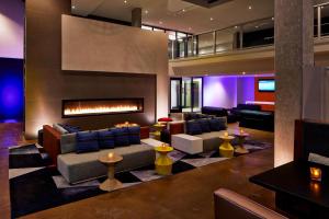a living room with a fireplace and couches at Aloft Seattle Redmond in Redmond