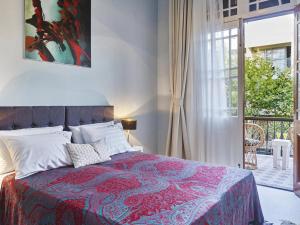 um quarto com uma cama com um cobertor vermelho e uma janela em Villa Sanyan - Adults Only em Rodes